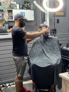 Man giving another man a haircut