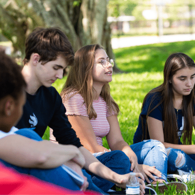 group of kids sitting on grass