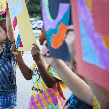 young people holding signs